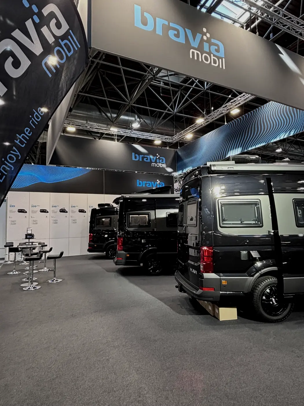 Reihe schwarzer Kastenwagen unter dem Hallendach der Messe Düsseldorf